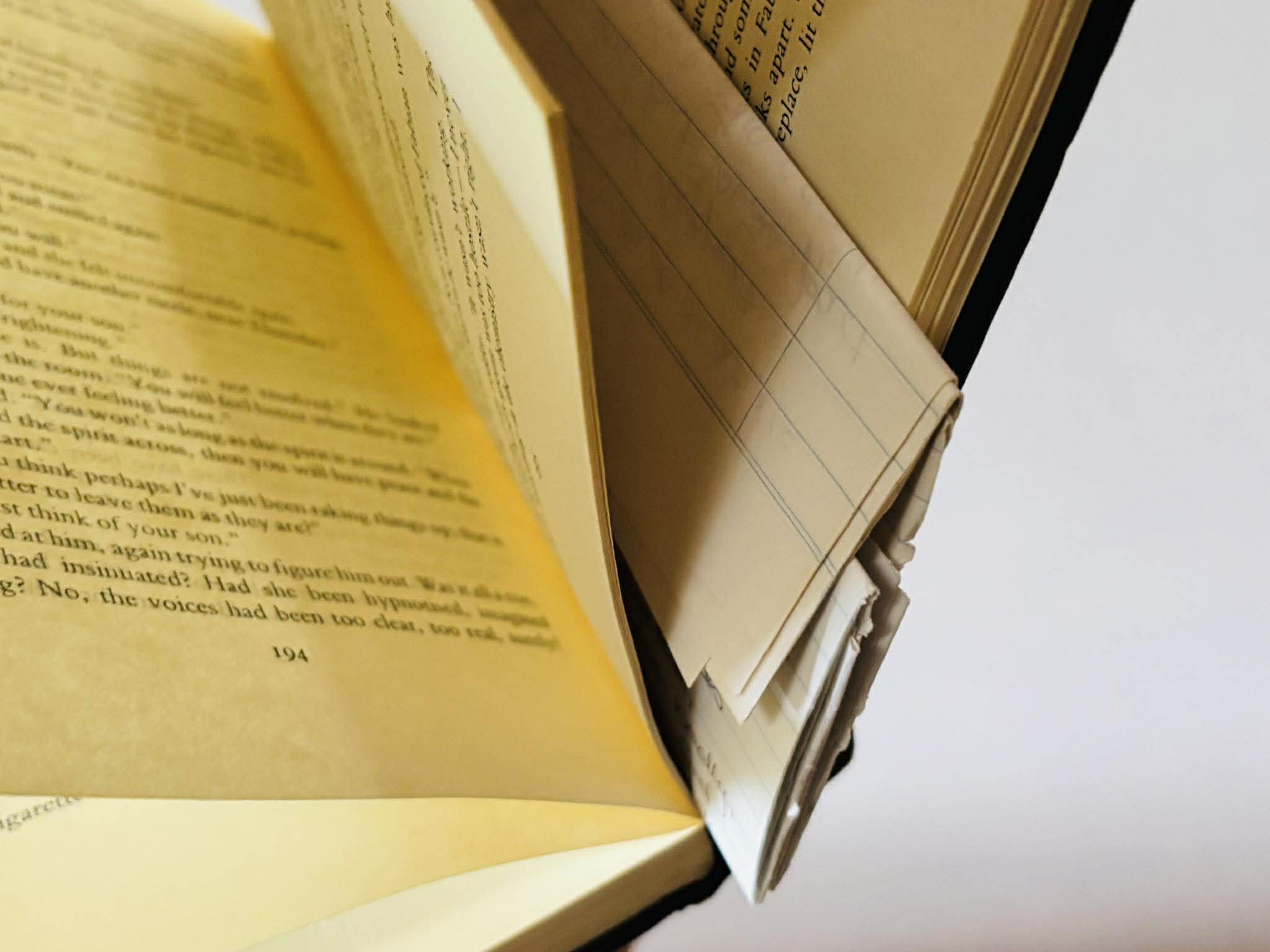 A folded many-paged letter hidden in the pages of a hardback book